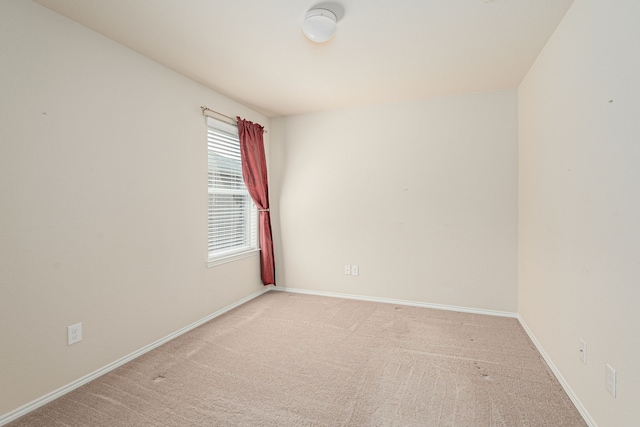 empty room with light colored carpet and baseboards