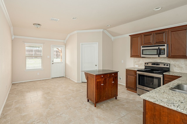 kitchen featuring light stone counters, backsplash, appliances with stainless steel finishes, and ornamental molding