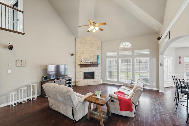 9645 Salvia Dr, Fort Worth, TX 76177 - living room with high vaulted ceiling, a ceiling fan, arched walkways, a stone fireplace, and dark wood-style flooring