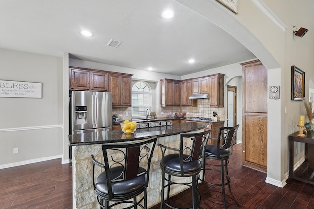 9645 Salvia Dr, Fort Worth, TX 76177 - kitchen featuring stainless steel appliances, arched walkways, backsplash, a breakfast bar, and a center island