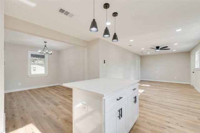 kitchen with light wood finished floors, visible vents, open floor plan, pendant lighting, and white cabinets