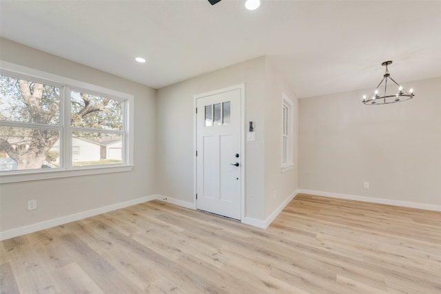 entryway with light wood finished floors, a notable chandelier, recessed lighting, and baseboards