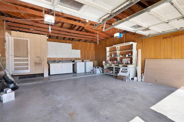4021 Kenley St, Fort Worth, TX 76107 - garage with washer and dryer, wooden walls, a garage door opener, and a workshop area