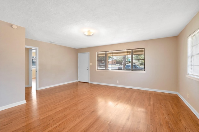 4021 Kenley St, Fort Worth, TX 76107 - spare room with baseboards, plenty of natural light, a textured ceiling, and light wood-style flooring