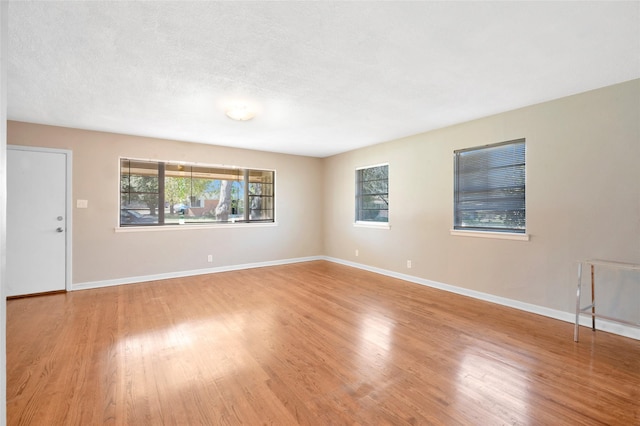 4021 Kenley St, Fort Worth, TX 76107 - unfurnished living room with a textured ceiling, baseboards, and wood finished floors