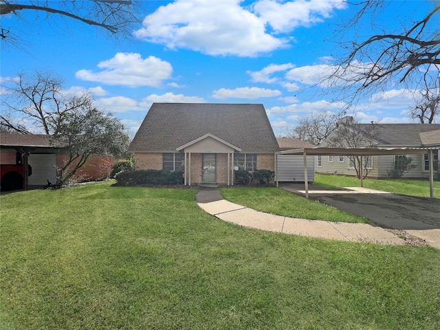 cape cod-style house with brick siding, a detached carport, a shingled roof, and a front lawn