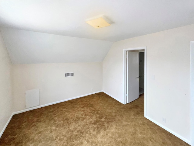 additional living space with lofted ceiling, baseboards, visible vents, and carpet floors
