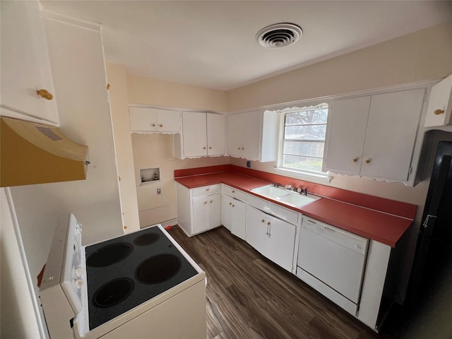 kitchen with white appliances, dark wood-style floors, white cabinets, visible vents, and a sink