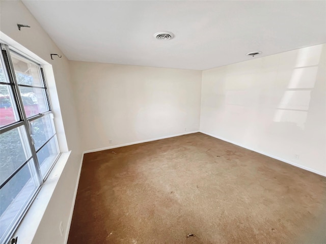 carpeted empty room featuring baseboards and visible vents