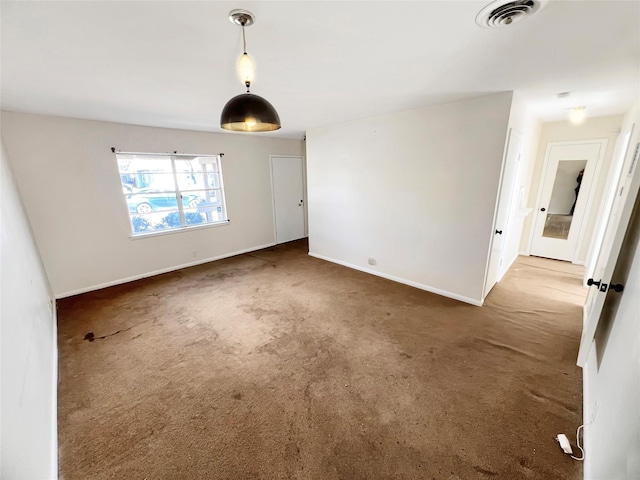 spare room featuring baseboards, visible vents, and carpet