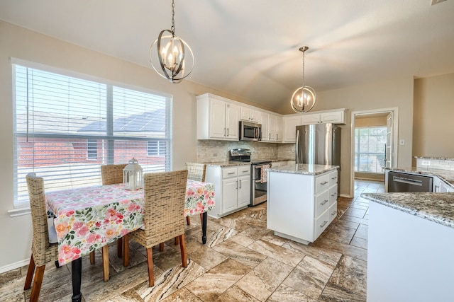 2710 Chalmers Ct, Rockwall, TX 75032 - kitchen with appliances with stainless steel finishes, a chandelier, backsplash, white cabinetry, and lofted ceiling