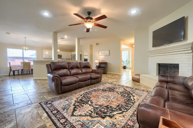 2710 Chalmers Ct, Rockwall, TX 75032 - living room featuring ceiling fan, stone tile flooring, baseboards, recessed lighting, and a fireplace