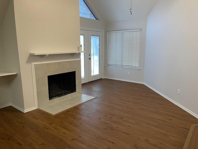 unfurnished living room with baseboards, a fireplace, dark wood-style flooring, and vaulted ceiling