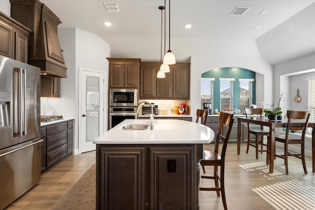 kitchen with visible vents, a sink, light countertops, light wood-style floors, and appliances with stainless steel finishes