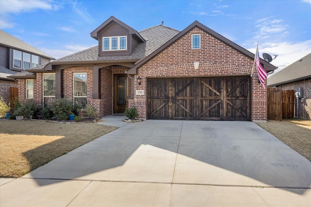 view of front facade featuring brick siding, an attached garage, concrete driveway, and roof with shingles