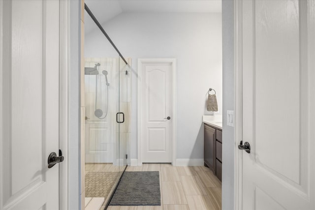 bathroom featuring a stall shower, vanity, and baseboards