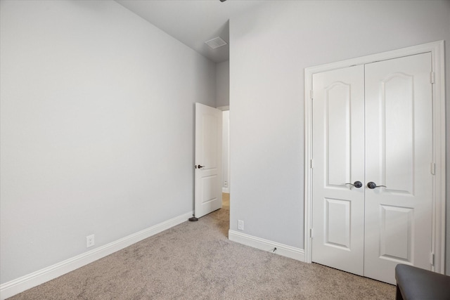 unfurnished bedroom with a closet, visible vents, baseboards, and carpet