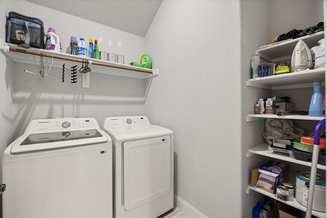 washroom with laundry area, washer and dryer, and baseboards