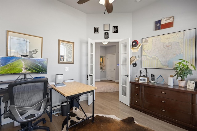 office area with baseboards, french doors, a ceiling fan, and light wood-style floors