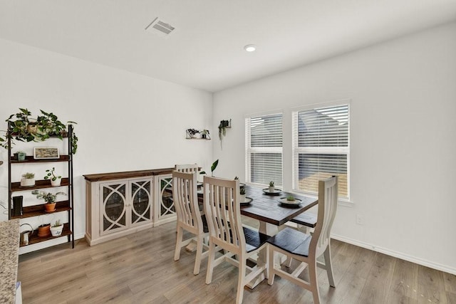 dining area featuring visible vents, baseboards, and wood finished floors