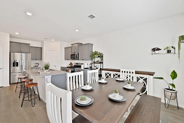 dining room featuring recessed lighting, visible vents, light wood finished floors, and baseboards