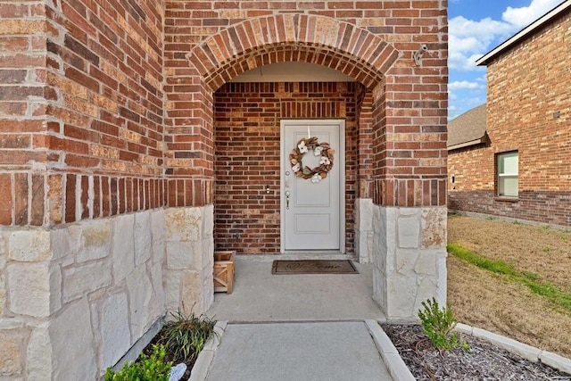 view of exterior entry with brick siding