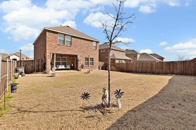 back of property with a patio area, a fenced backyard, and brick siding