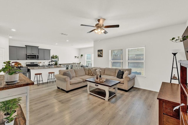 living area with visible vents, baseboards, ceiling fan, light wood-type flooring, and recessed lighting