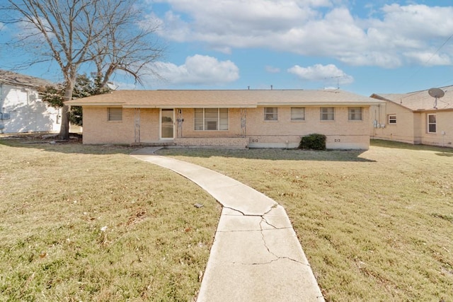 rear view of property featuring brick siding and a lawn