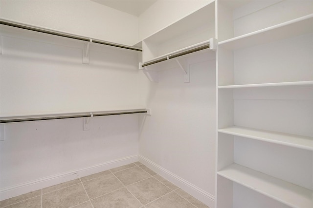 walk in closet with light tile patterned floors