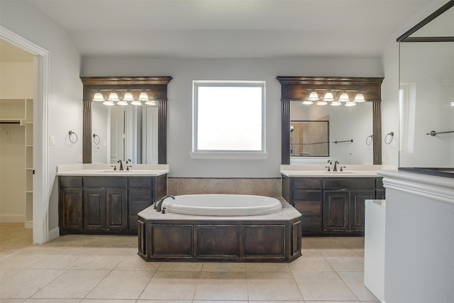 bathroom with a sink, a garden tub, two vanities, and tile patterned flooring