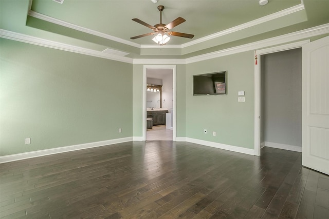 empty room with baseboards, a raised ceiling, dark wood-type flooring, and ceiling fan