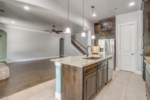 kitchen with light tile patterned floors, visible vents, arched walkways, and a sink