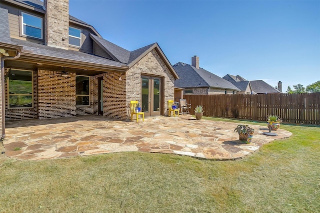 view of yard with a ceiling fan, a patio, fence, and french doors