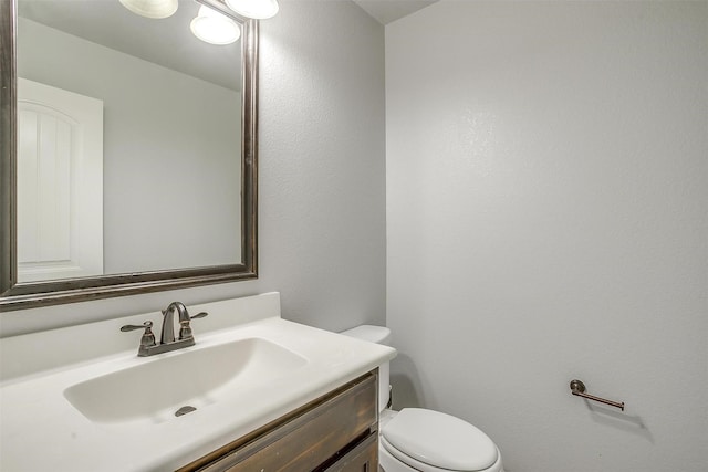 half bathroom featuring toilet and vanity