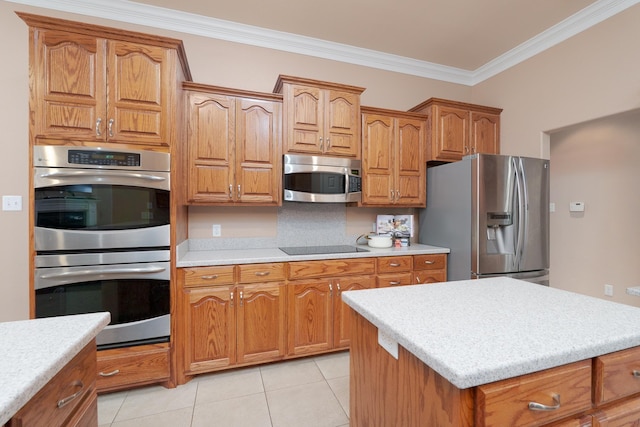 kitchen featuring brown cabinets, appliances with stainless steel finishes, light countertops, and crown molding