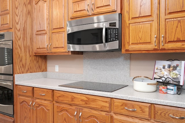 kitchen featuring light countertops, brown cabinets, and stainless steel appliances