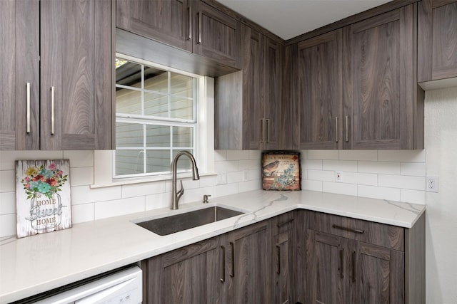 kitchen featuring light stone counters, a sink, decorative backsplash, dark brown cabinets, and dishwasher