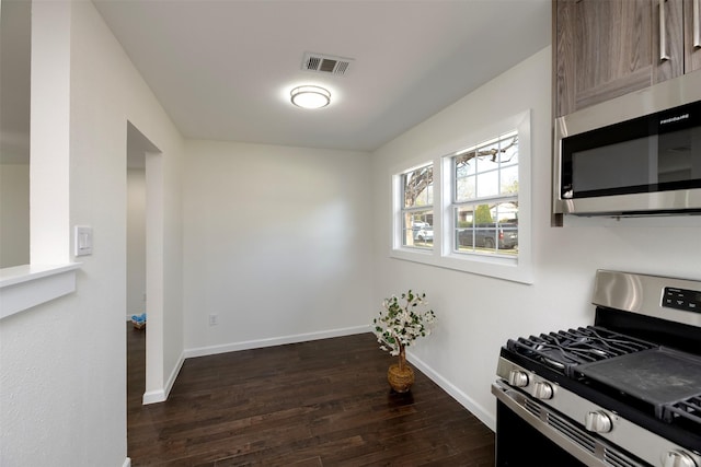 kitchen with visible vents, appliances with stainless steel finishes, baseboards, and dark wood-style flooring