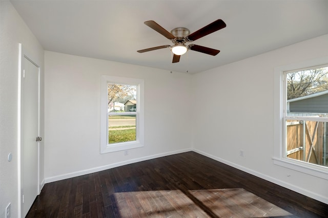 empty room with plenty of natural light, dark wood-style floors, and baseboards