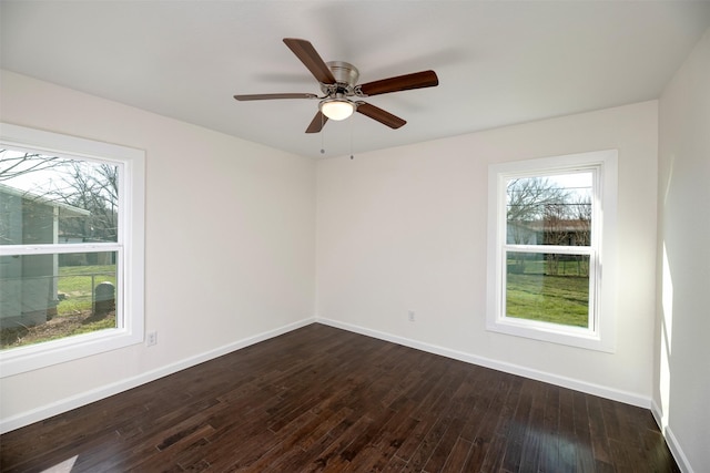 empty room with baseboards, dark wood-type flooring, and a ceiling fan