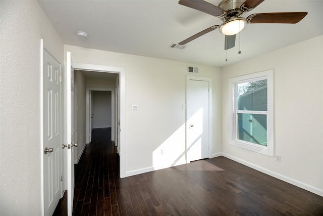 unfurnished bedroom featuring a ceiling fan, baseboards, visible vents, and dark wood-style flooring