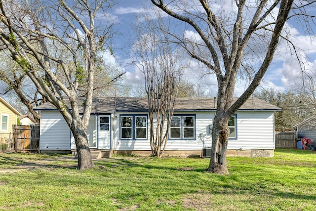 single story home featuring roof with shingles, a front yard, and fence