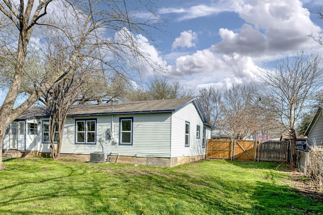 back of house featuring a gate, fence, a yard, and cooling unit