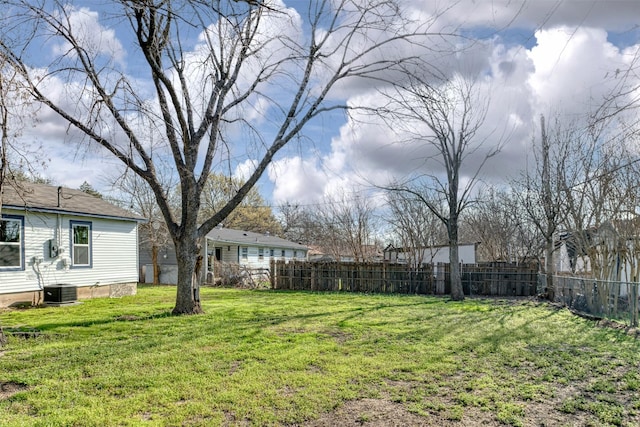 view of yard with central AC and fence