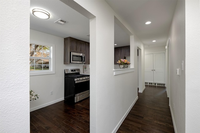 hallway featuring recessed lighting, visible vents, baseboards, and dark wood-style flooring