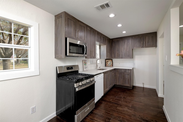 kitchen featuring visible vents, tasteful backsplash, appliances with stainless steel finishes, light countertops, and dark wood-style flooring