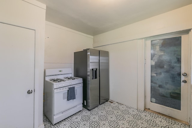 kitchen featuring stainless steel fridge with ice dispenser, light tile patterned flooring, and white gas range oven