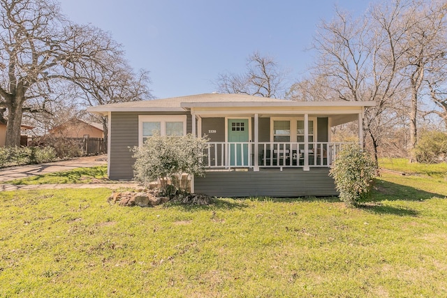 bungalow-style house with covered porch, a front yard, and fence