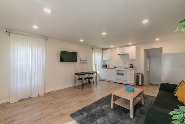 living room featuring light wood-style flooring, recessed lighting, and baseboards